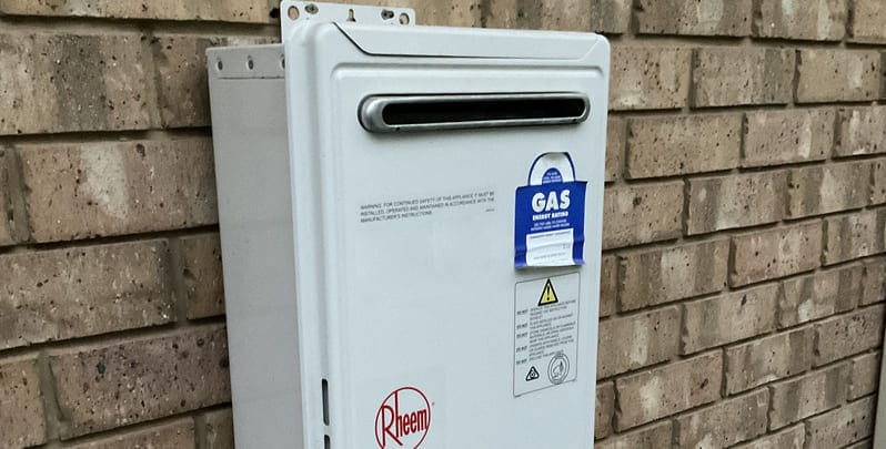 Rheem gas hot water system installed on outside wall of a home. 